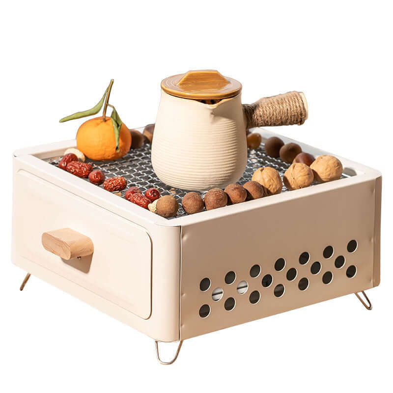 Square outdoor barbecue oven featuring a charcoal grill and a stylish design with fruits and nuts on top.